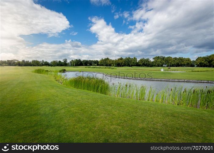 Beautiful view of golf course with water hindrance at sunny day