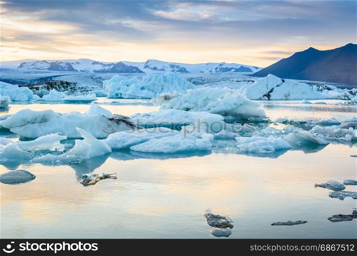 Beautiful view of icebergs in Jokulsarlon glacier lagoon at sunset, Iceland, global warming concept, selective focus