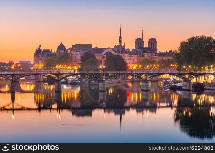 Beautiful view of Ile de la Cite and Pont des Arts at sunrise in Paris, France. Night Ile de la Cite in Paris, France