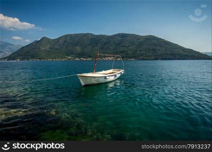 Beautiful view of Kotor bay with moored white wooden rowboat