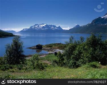 Beautiful view of ocean fjord in Norway with snow mountains