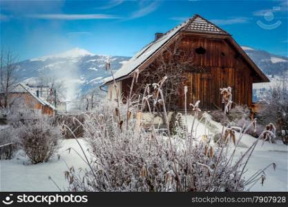 Beautiful view of old wooden barn in Austrian Alps covered by snow
