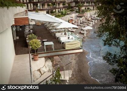 Beautiful view of restaurant with summer terrace on high cliff at Mediterranean sea