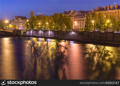 Beautiful view of riverside of Seine river at night in Paris, France. Night Ile de la Cite in Paris, France