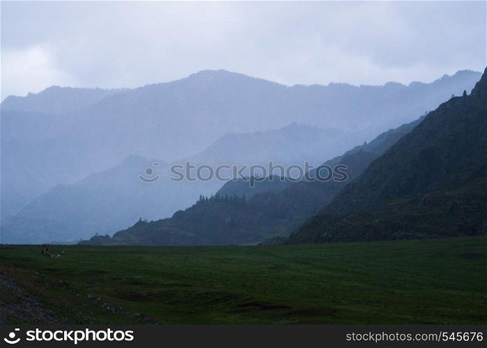 Beautiful view of the silhouettes of the Altai mountain ranges in rainy weather and fog.. Beautiful view of the silhouettes of the Altai mountain ranges in rainy weather and fog
