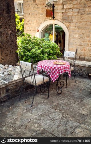 Beautiful view of two chairs and table on summer terrace of old restaurant