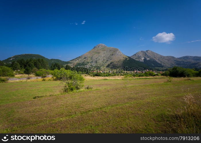 Beautiful view on high mountain and fields at sunny day