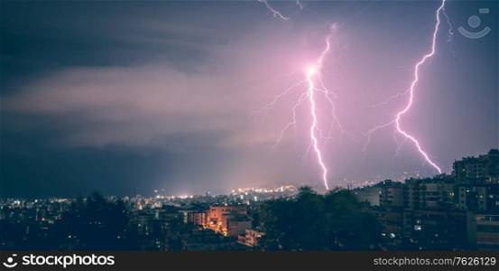 Beautiful view on two lightnings over city at night, beauty and danger of nature, summer time weather in Beirut, Lebanon