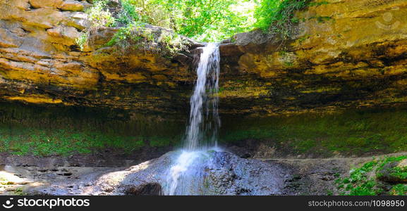 Beautiful view to famous Moldovan waterfall located near the village Saharna, Rezina region, Republic of Moldova. Wide photo. seen on a bright sunny summer day. Wide photo.