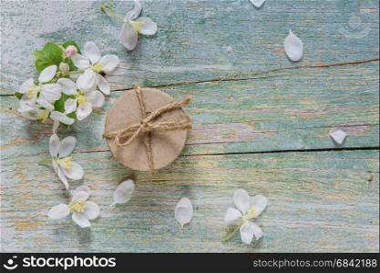 Beautiful vintage background from old blue boards, white spring flowers and round gift box