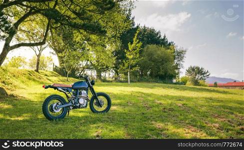 Beautiful vintage custom motorcycle parked on the field. Custom motorcycle parked on the field