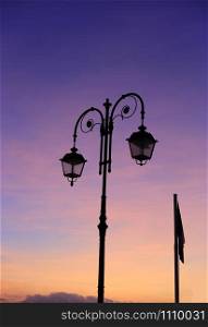 Beautiful vintage street lamp against a bright sunrise sky, Alassio, Liguria, Italy