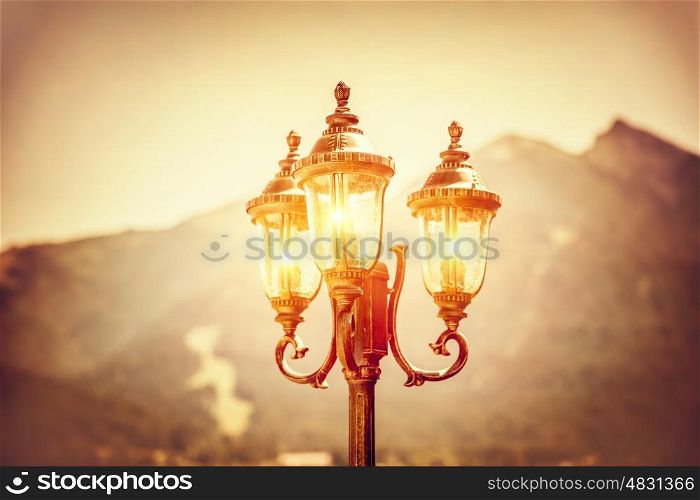 Beautiful vintage street lamp glowing in the evening over high mountains background, amazing antique architecture detail, Seefeld, Austria, Europe