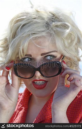 Beautiful vintage styled blonde haired teenage girl wearing sunglasses