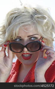 Beautiful vintage styled blonde haired teenage girl wearing sunglasses