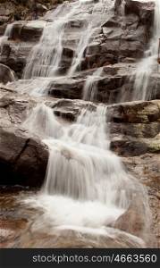 Beautiful waterfall falling on a stone wall