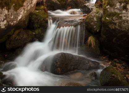 Beautiful waterfall falling on a stones with moss