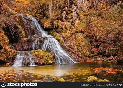 Beautiful waterfall in forest, autumn landscape.