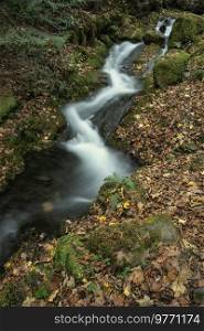 Beautiful waterfall landscape image in vibrant Autumn woodland in Lake District