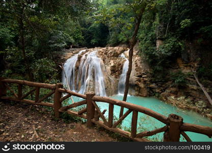beautiful waterfall with blue water in green forest