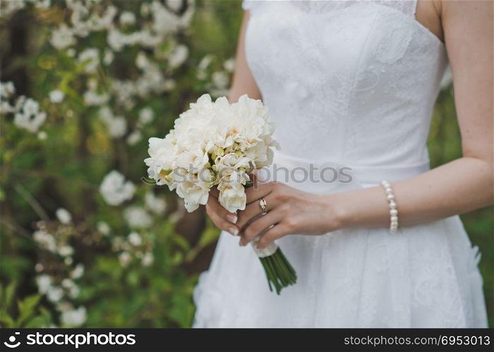 Beautiful wedding bouquet in hands of the newly-married couple on wedding.