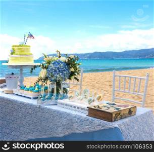 Beautiful wedding cake on the table. Table with the cake on the beach of tropics.