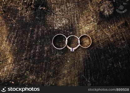 Beautiful wedding rings lie on wooden surface against background. Declaration of love, spring. Wedding card, Valentine's Day greeting. Wedding rings. Wedding day details.. Beautiful wedding rings lie on wooden surface against background. Valentine's Day. Wedding rings. Wedding day details