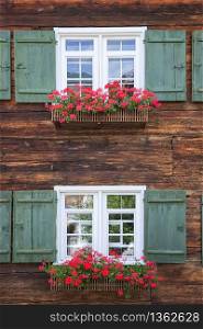 Beautiful windows frame with flower boxes. Colorful decoration on the windows. Rural window frame