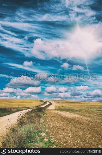 Beautiful windy countryside road against blue sky with clouds. Holiday and vacation concept.