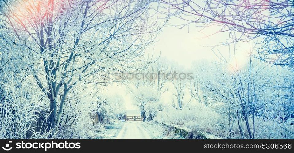 Beautiful winter country landscape with snow trees and road and gate