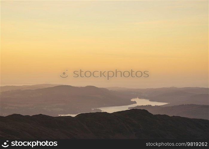 Beautiful Winter dawn landscape view from Red Screes in Lake District looking South towards Windermere with colorful vibrant sky