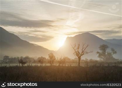 Beautiful Winter foggy sunrise over countryside around Crummock Water in Lake District England