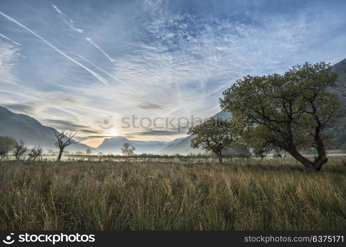 Beautiful Winter foggy sunrise over countryside around Crummock Water in Lake District England