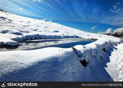 Beautiful winter lake landscape with reflection of blue sky