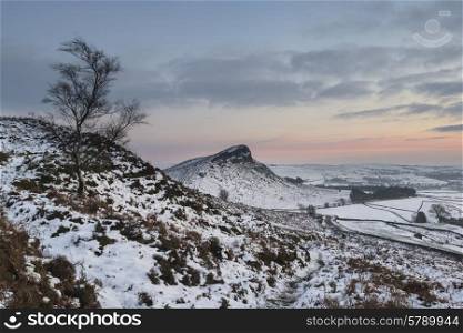 Beautiful Winter landscape at sunset over snow covered countryside