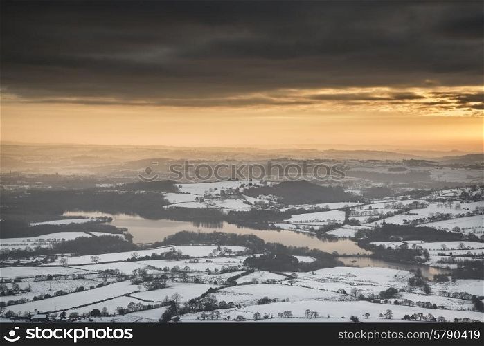 Beautiful Winter landscape at sunset over snow covered countryside