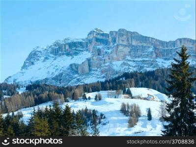 Beautiful winter rocky mountain landscape and houses on slope. Italy Dolomites, at the foot of Passo Gardena, South Tyrol.