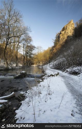 Beautiful Winter snow covered countryside landscape of river flowing with reflections