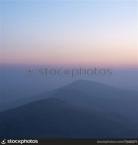 Beautiful Winter sunrise landscape image of The Great Ridge in the Peak District in England with mist hanging around the peaks