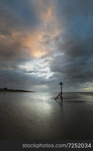 Beautiful Winter sunrise over West Wittering beach in Sussex England with wind blowing sand across the beach