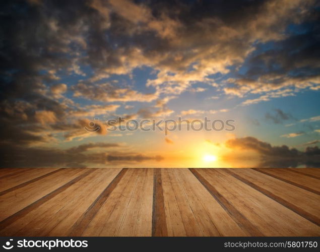 Beautiful Winter vibrant sunset sky reflected in sea with wooden planks floor