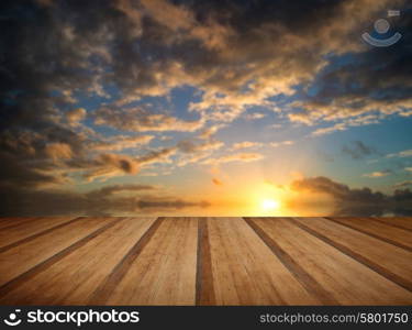 Beautiful Winter vibrant sunset sky reflected in sea with wooden planks floor