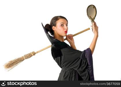 beautiful witch making funny face and keeping broom on shoulder