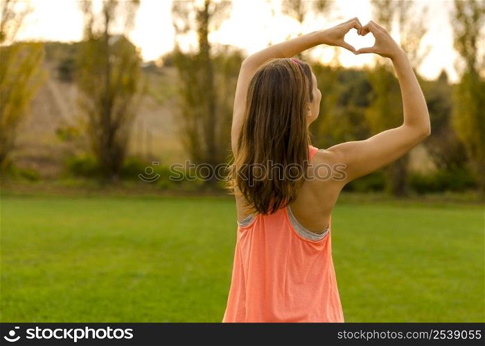Beautiful woman after the exercise making a hearth shape