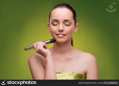 Beautiful woman applying make-up in beauty concept