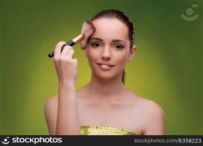 Beautiful woman applying make-up in beauty concept