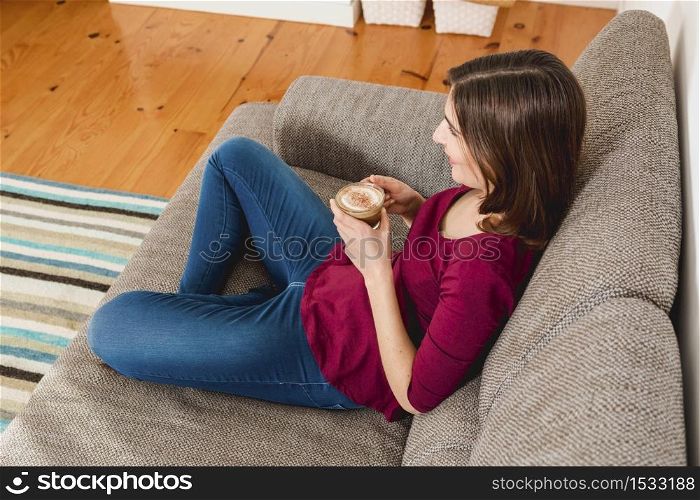 Beautiful woman at home drinking a cup pf tea