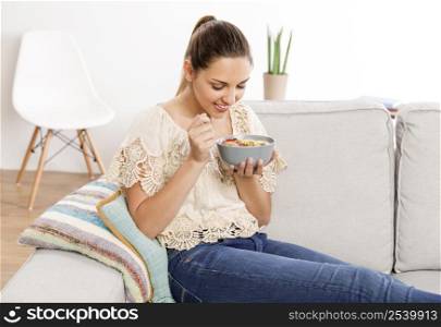 Beautiful woman at home eating a healthy bowl