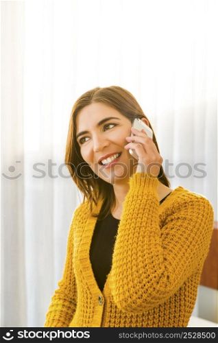 Beautiful woman at home making a phone call