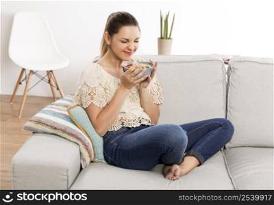 Beautiful woman at home smelling her bowl full of healthy food